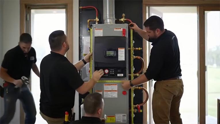 A Team Of HVAC technicians uses a tape measure to align a new high‑efficiency boiler unit during installation.